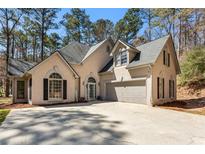 Charming two-story home featuring a well-manicured lawn, a welcoming entrance, and an attached garage at 5163 Holly Springs Dr, Douglasville, GA 30135