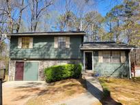 Split-level home with painted siding, stone accents, and attached garage at 198 Lexington Ct, Riverdale, GA 30274
