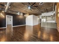 Contemporary living room with hardwood floors, industrial ceiling, and open kitchen space at 3235 Roswell Ne Rd # 421, Atlanta, GA 30305