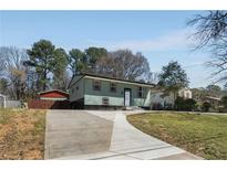 Charming home with a long driveway and a well-maintained lawn at 6370 Boca Grande Blvd, Forest Park, GA 30297