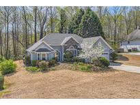 Charming single-Gathering home featuring stone accents and a manicured lawn, set amidst a lush, wooded backdrop at 534 Creekstone Dr, Jonesboro, GA 30236