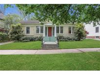 Charming single-story home featuring a well-manicured lawn, complemented by lush greenery and a inviting red front door at 1105 Saint Louis Ne Pl, Atlanta, GA 30306
