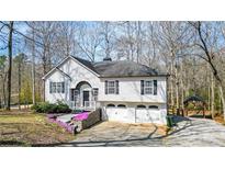 Charming home featuring a 2-car garage, stone accents, flowering plants, and lovely front yard at 416 Delane Dr, Dallas, GA 30157