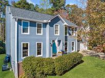 Charming two-story home with blue siding, a manicured lawn and neatly trimmed shrubbery at 210 Timber Laurel Ct, Lawrenceville, GA 30043