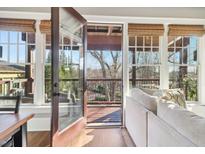 Bright living room featuring hardwood floors, neutral walls, and access to a deck with wooded views at 5910 Bond St # 401, Cumming, GA 30040