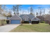 Charming single-story brick home with a well-manicured lawn, blue garage door, and inviting curb appeal at 3191 Mineral Ridge Ln, Stone Mountain, GA 30087