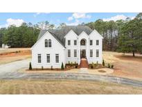 Stunning white brick two-story home with striking architectural details and a meticulously maintained lawn at 636 Ginger Cake Rd, Fayetteville, GA 30214