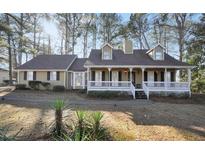 Charming home with a welcoming front porch and a well-manicured lawn surrounded by mature trees at 3281 Old Salem Rd, Conyers, GA 30013