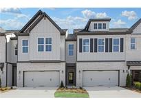 Beautiful townhome with light gray siding, brick accents, and a two-car garage at 2568 Silver Star Ne Dr, Marietta, GA 30066