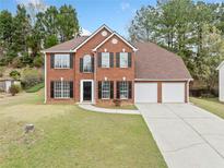 Charming two-story brick home with a well-manicured lawn and a two-car garage at 3920 Cain Mill Dr, Lithonia, GA 30038