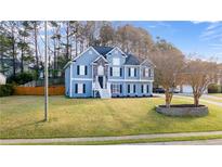 Charming two-story blue home with stone accents, black shutters, and a well-maintained lawn at 633 Windy Mill Xing, Temple, GA 30179
