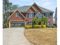 Charming two-story brick home with well-manicured landscaping and attached two-car garage at 1921 Paddock Path Nw Dr, Acworth, GA 30102