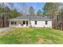 Charming, single-story white home with a welcoming front yard and a convenient carport at 2374 Buchanan Hwy, Dallas, GA 30157