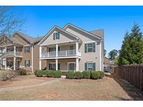 Charming two-story home with a cozy front porch and well-manicured landscaping on a bright day at 307 Montgomery Way, Woodstock, GA 30188