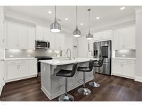 Modern kitchen features a center island with bar seating, stainless steel appliances, and ample cabinet space at 2128 Cosette Ln, Kennesaw, GA 30152