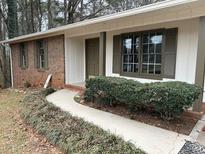 Charming brick and white house with well-manicured front yard landscaping and walkway at 213 Sharon Drive, Canton, GA 30115