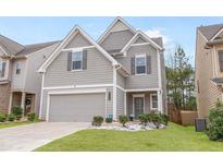 Charming home showcasing a well-manicured lawn, gray siding, and attached two-car garage at 3200 Baylor Cir, Mcdonough, GA 30253