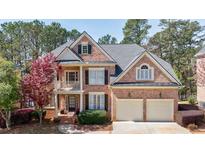 Beautiful two-story brick home featuring a two-car garage, manicured landscaping, and a charming front porch at 3314 Islesworth Trce, Duluth, GA 30097
