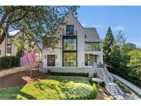 Beautiful two-story home featuring a manicured lawn, gray trim, and large, black-trimmed windows at 96 The Prado Ne, Atlanta, GA 30309