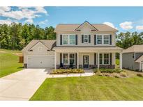 Charming two-story home with a welcoming front porch and manicured lawn at 1661 Flagstone Ln, Conyers, GA 30012
