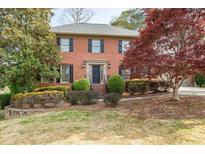 Charming two-story brick home featuring a landscaped front yard and classic architectural details at 635 Holyrood Way, Alpharetta, GA 30022
