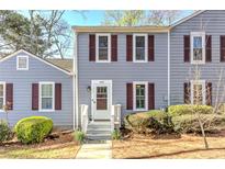Charming townhouse exterior with gray siding and a cozy front entrance, complimented by lush green bushes at 403 Oak Harbor Ct, Marietta, GA 30066