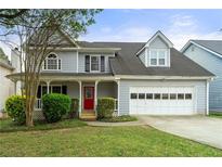 Charming two-story home with a well-manicured lawn and a bright red front door at 2802 Oak Meadow Ln, Snellville, GA 30078