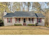 Charming single-story home featuring a welcoming front porch with red shutters and a well-maintained yard at 4565 Canebrake Ct, Powder Springs, GA 30127