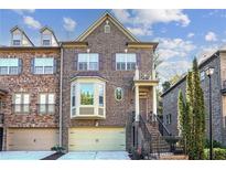 Inviting two-story brick townhouse with a front-facing garage and charming architectural details at 2766 Birch Grove Se Ln # 11, Marietta, GA 30067