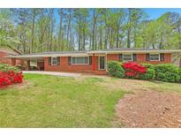 Charming brick home with a well-maintained lawn and vibrant red shrubbery at 1933 Silvastone Dr, Decatur, GA 30033
