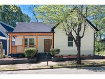 Charming home featuring a covered porch, complemented by manicured landscaping and a lovely tree at 514 English Nw Ave, Atlanta, GA 30318