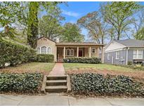 Charming single-story home featuring a brick walkway, red door, and lush landscaping at 650 Somerset Ne Ter, Atlanta, GA 30306