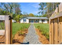 Charming home with a stone path, lush lawn, and wooden fence, offering a serene curb appeal at 2151 Blaylock Dr, Marietta, GA 30062