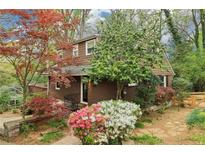 Charming two-story home with blooming azaleas and mature trees in a lush, landscaped yard at 2891 Ridgemore Nw Rd, Atlanta, GA 30318