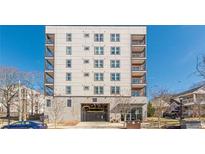 Modern condo building featuring multi-story living, balconies, and a covered parking garage at 525 Parkway Ne Dr # 103, Atlanta, GA 30308