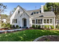 Charming white brick home with landscaped yard, arched entry and black shutters, perfect curb appeal at 1751 Meadowdale Ne Ave, Atlanta, GA 30306