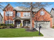 Beautiful two-story brick home with a well-manicured lawn and inviting curb appeal at 3721 Lake Enclave Way, Atlanta, GA 30349