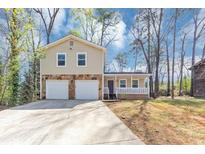 Charming home with stone accents, a covered porch, a two-car garage, and ample parking space at 5307 Mountain Village Ct, Stone Mountain, GA 30083