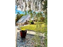 Charming two-story home with a well-manicured front yard and lush landscaping around the property at 3810 Galloway Dr, Roswell, GA 30075