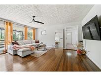 Inviting living room with hardwood floors, large windows, and a comfortable, neutral-toned sectional sofa at 1755 Fairburn Sw Rd, Atlanta, GA 30331