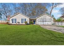 Charming single-story home with well-manicured lawn, two-car garage, and inviting curb appeal at 5720 Crow Dr, Cumming, GA 30041