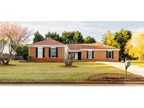 Charming single-story brick home with a well-maintained lawn and dark shutters, complete with mature trees at 1250 Great Oaks Se Dr, Conyers, GA 30013