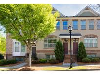 Charming townhome exterior featuring a brick facade, landscaped garden, and inviting front entrance at 4329 Tacoma Trce, Suwanee, GA 30024