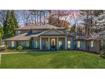 Stately brick home featuring a manicured lawn, covered front porch, and beautiful architectural details at 5780 Riverwood Dr, Sandy Springs, GA 30328