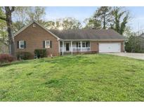 Traditional brick home with an attached garage and a welcoming, covered front porch at 2119 Amherst Se Trl, Conyers, GA 30094