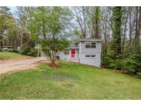 Charming gray split level home with a bright red front door and a lush green lawn at 3436 Misty Valley Rd, Decatur, GA 30032