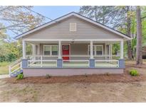 Charming single-story home with a cozy front porch and a red front door at 1248 W Ridge Ave, Stone Mountain, GA 30083