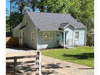 Charming blue bungalow with a well-manicured lawn, inviting entrance, and paved driveway at 2535 Judson Ave, East Point, GA 30344
