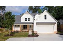 Charming two-story home features a covered porch, gabled roof and an attached garage at 1698 Cunningham Sw Rd, Marietta, GA 30008