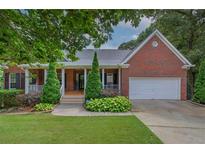 Charming brick home with a well-manicured lawn, inviting front porch, and a two car garage at 51 Muirfield Ct, Hiram, GA 30141